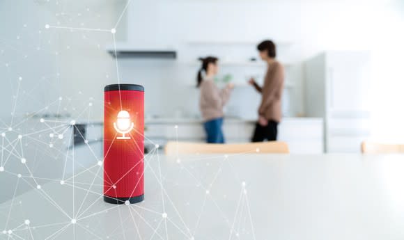 A smart speaker with a couple in the background.