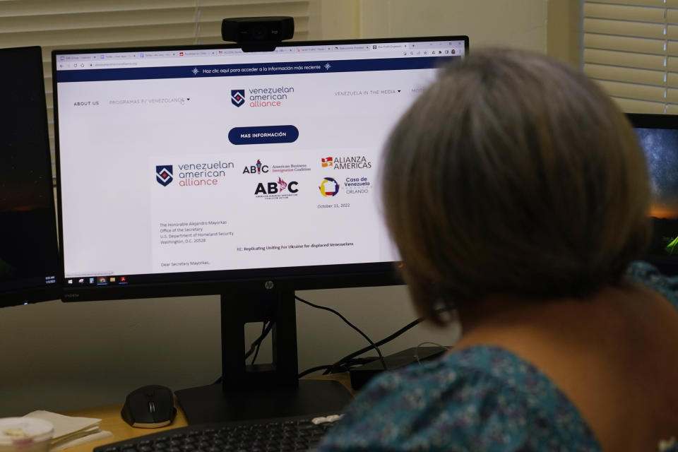 Maria Antonieta Diaz looks at a website for Venezuelans seeking to enter the U.S., Thursday, Jan. 5, 2023, in Miramar, Fla. Diaz has sponsored several Venezuelans under a parole program started in October. The Biden administration announced an expansion of that program to Cubans, Nicaraguans and Haitians seeking to enter the U.S.. (AP Photo/Marta Lavandier)