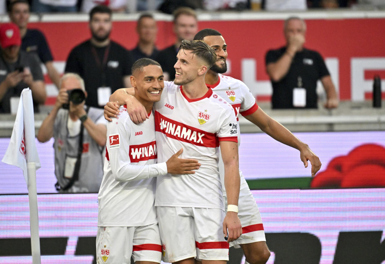 From left, Stuttgart's Jamie Leweling, Ermedin Demirovic and Josha Vagnoman celebrate their side's third goal during a German Bundesliga soccer match between VfB Stuttgart and Borussia Dortmund in Stuttgart Germany, Sunday, Sept. 22, 2024. (Jan-Philipp Strobel/dpa via AP)