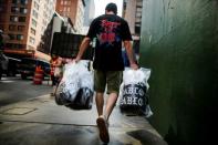 A shopper carries "The Life of Pablo" merch after visiting a pop up store featuring fashion by Kanye West in Manhattan, New York, U.S., August 19, 2016. REUTERS/Eduardo Munoz