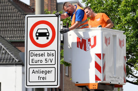 FILE PHOTO: Traffic signs which ban diesel cars are installed by workers at the Max-Brauer Allee in downtown Hamburg, Germany May 16, 2018. REUTERS/Fabian Bimmer/File Photo