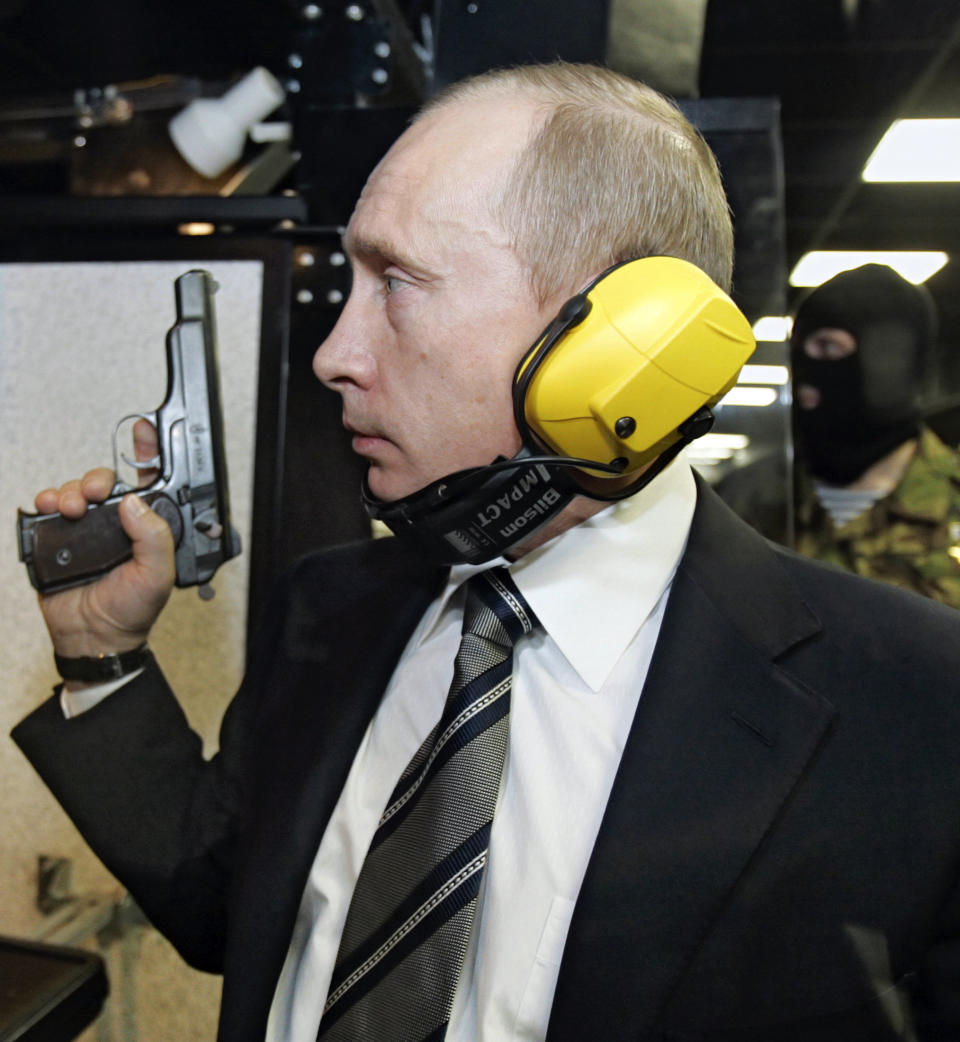 Putin stands with a gun at a shooting gallery of the new GRU military intelligence headquarters building in Moscow on Nov. 8, 2006.