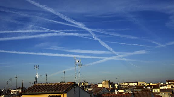 Contrails from jet aircraft fill the sky over Florence, Italy.