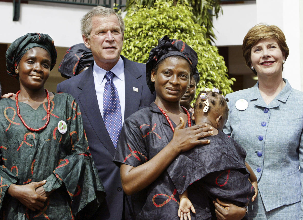 President George W. Bush and first lady Laura Bush greet local mothers affected by AIDS with their HIV-free children in the courtyard of the Abuja National Hospital and laboratory in Abuja, Nigeria, the last stop on his African tour, on July 12, 2003. (J. Scott Applewhite / AP)