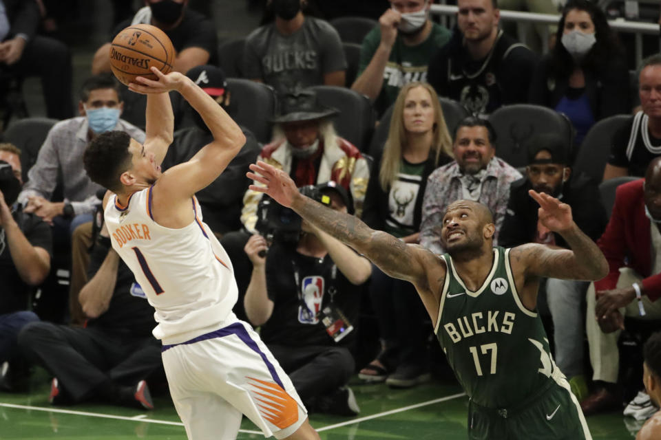 Phoenix Suns' Devin Booker (1) shoots against Milwaukee Bucks' P.J. Tucker (17) during the second half of Game 3 of basketball's NBA Finals, Sunday, July 11, 2021, in Milwaukee. (AP Photo/Aaron Gash)