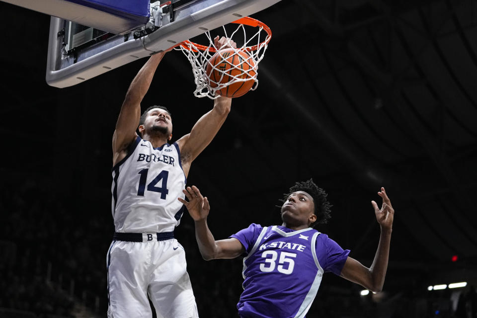 Butler guard Pierce Thomas (14) is fouled as he gets a dunk over Kansas State forward Nae'Qwan Tomlin (35) in the first half of an NCAA college basketball game in Indianapolis, Wednesday, Nov. 30, 2022. (AP Photo/Michael Conroy)