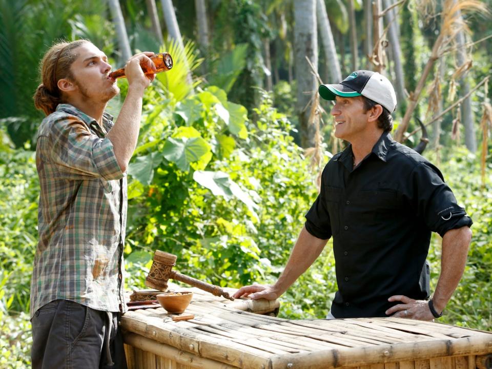 Malcolm Freberg drinking next to Jeff Probst on survivor