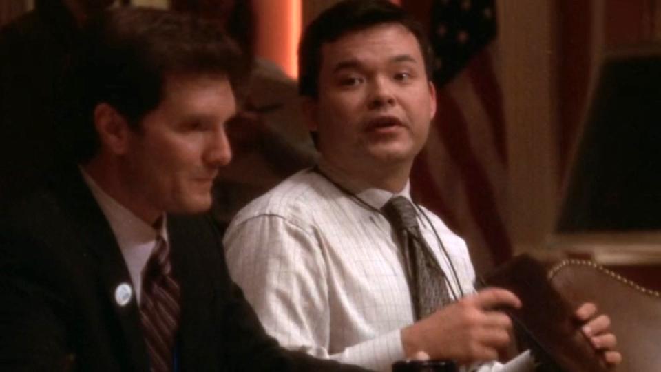 Peter James Smith as Ed speaks during a meeting on The West Wing.