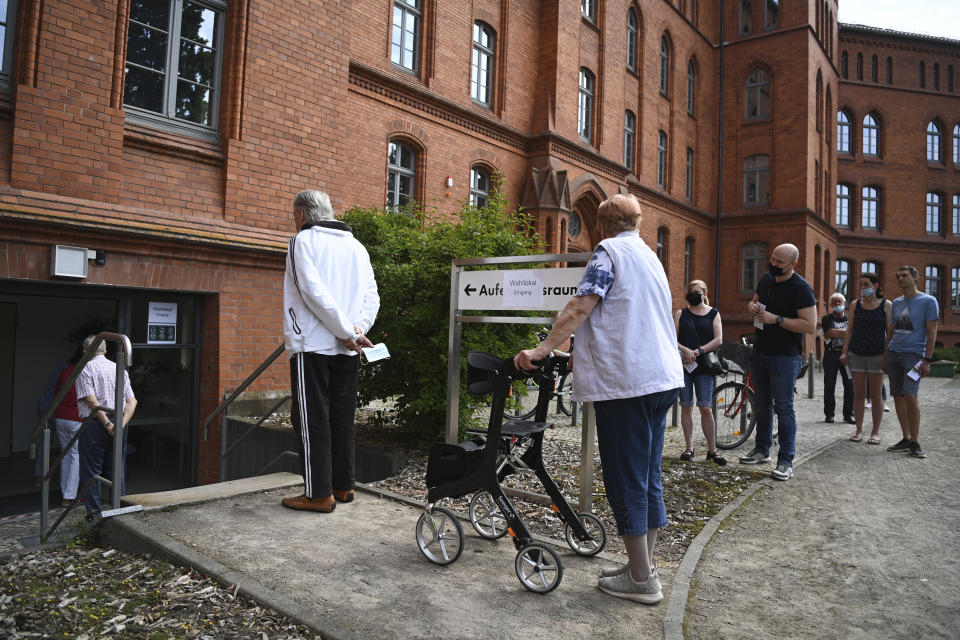 Voters queue outside a polling station in Wittenberg, Germany Sunday June 6, 2021 for the state election in Saxony-Anhalt. The election for the new state parliament in Saxony-Anhalt is the last state election before the federal election in September 2021. (Robert Michael/DPA via AP)