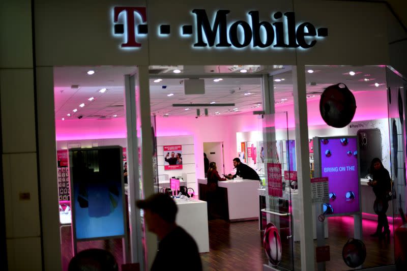 FILE PHOTO: A T-Mobile employee assists a customer as holiday shopping accelerates at the King of Prussia Mall