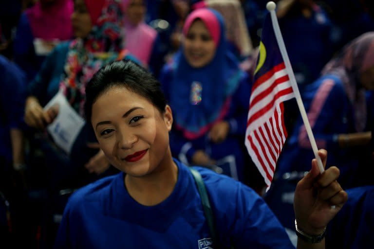 A supporter of Malaysia's ruling coalition waves a flag during a rally at a stadium in Bukit Jalil, a suburb of Kuala Lumpur, on April 6, 2013. The upcoming vote is tipped to be the closest ever, driven by concerns over corruption, the rising cost of living and high crime under an UMNO-dominated coalition which has ruled Malaysia since independence in 1957