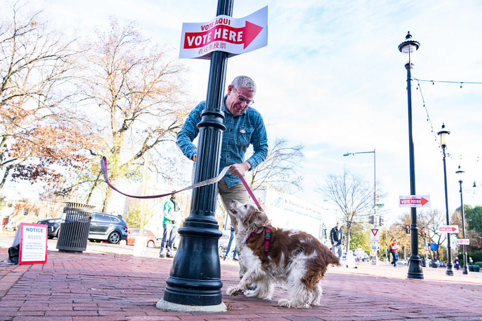 A man unties his dog after voting at Eastern Market in the Capitol Hill neighborhood of Washington, DC, on Nov. 8, 2022.