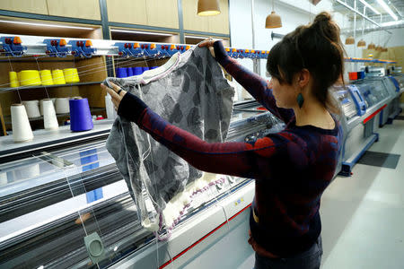 A staff member checks the quality of a knitted sweater at the production line inside the Adidas Knit for You store in Berlin, Germany March 7, 2017. Picture taken March 7, 2017. REUTERS/Fabrizio Bensch