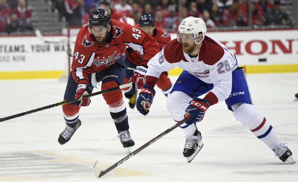 Washington Capitals Tom Wilson (43) and Montreal Canadiens Jeff Petry (26) chase down the puck during the second period of their NHL hockey game in Washington, Thursday, April 4, 2019. (AP Photo/Susan Walsh)