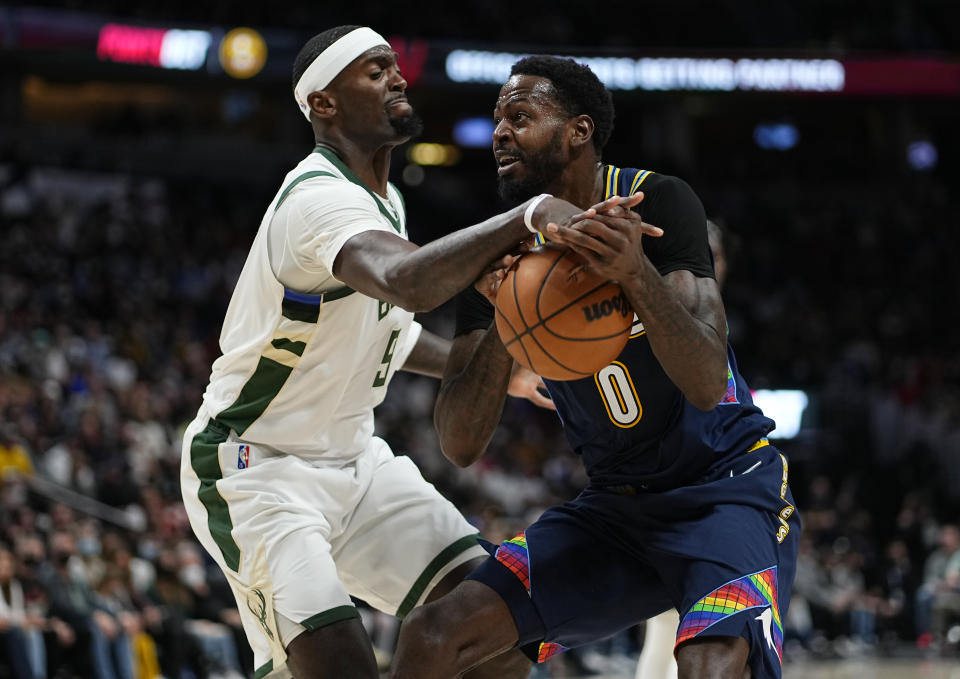 Milwaukee Bucks center Bobby Portis (9) knocks the ball from the hands of Denver Nuggets forward JaMychal Green (0) during the second quarter of an NBA basketball game Friday, Nov. 26, 2021, in Denver. (AP Photo/Jack Dempsey)