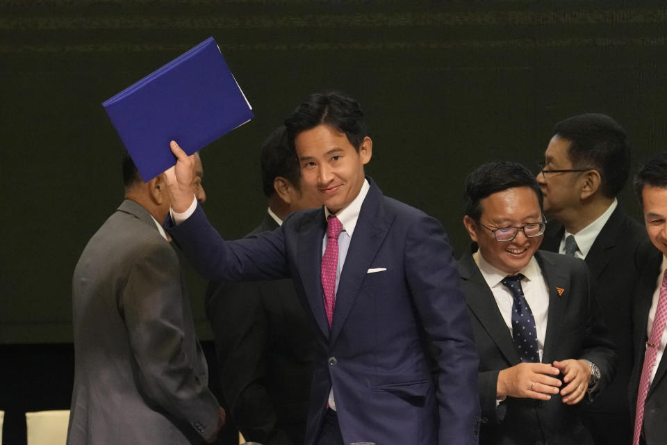 Leader of Move Forward Party Pita Limjaroenrat, left, waves after signing a memorandum of understanding on attempt to form a coalition government between Move Forward Party and other parties during a news conference in Bangkok, Thailand, Monday, May 22, 2023. Move Forward won the most seats in the May 14 election, and it has formed a coalition that seeks to become the government when Parliament selects a prime minister in July. (AP Photo/Sakchai Lalit)