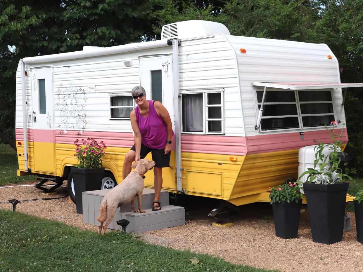 Adrienne Smith with one of her dogs outside her Dolly Parton-themed RV.