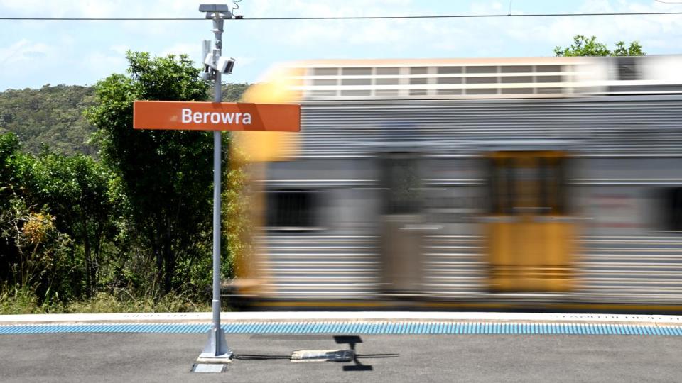 A train speeds past a station.