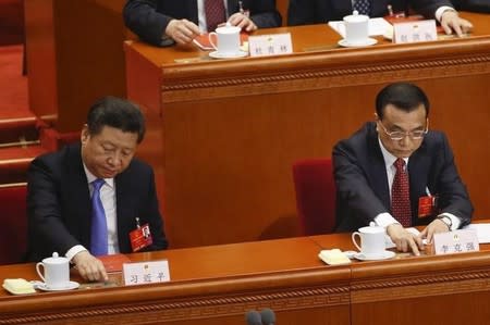 China's President Xi Jinping (L) and Premier Li Keqiang vote during the closing ceremony of China's National People's Congress (NPC) at the Great Hall of the People in Beijing, China, March 16, 2016. REUTERS/Kim Kyung-hoon