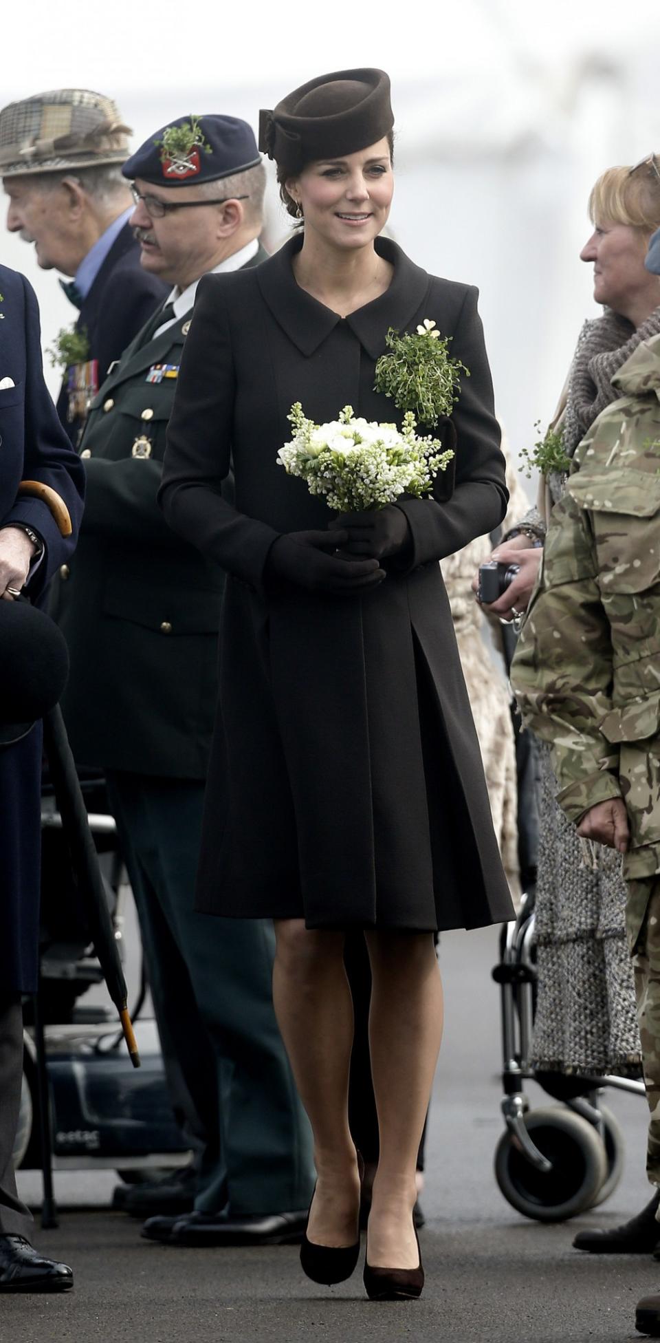 <p>The Duchess pinned both the late Queen Mother’s gold shamrock brooch to her label and a bouquet of shamrocks. (Photo: PA) </p>