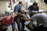 People help an injured man during clashes with Turkish police officers on July 25, 2015 at Gazi district in Istanbul
