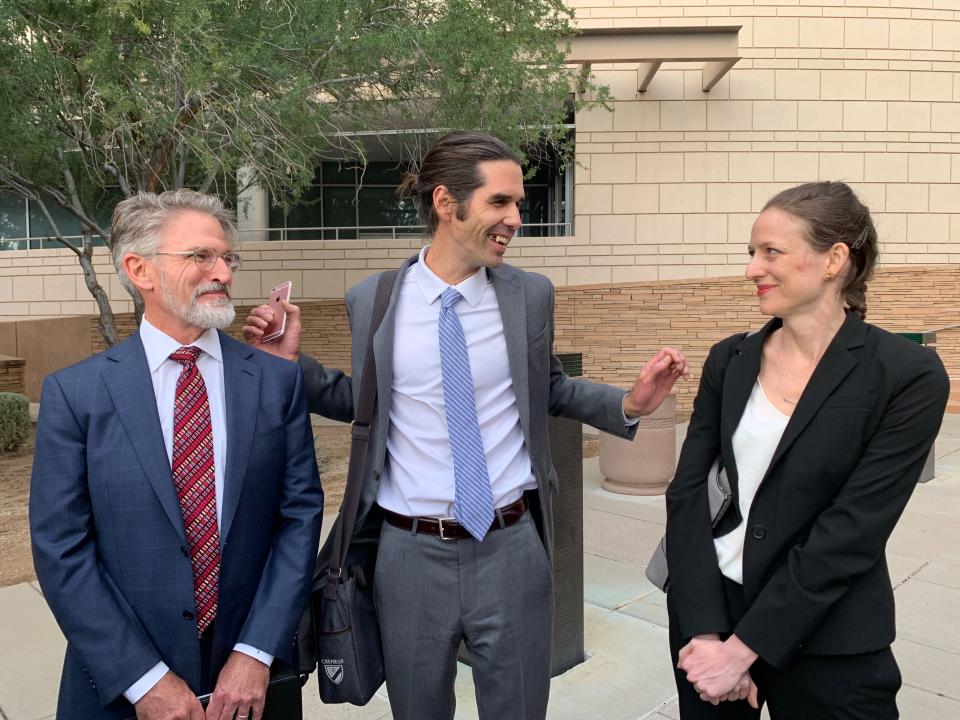 Scott Warren, center, of Ajo, Ariz., celebrates with his attorneys Amy Knight, right, and Greg Kuykendall outside court in Tucson, Ariz. on Wednesday, Nov. 20, 2019, after being acquitted of two counts of harboring in a case that garnered international attention. Prosecutors said Warren illegally helped two migrants avoid authorities. He said he was fulfilling his humanitarian duties by helping two injured men. (AP Photo/Astrid Galvan)