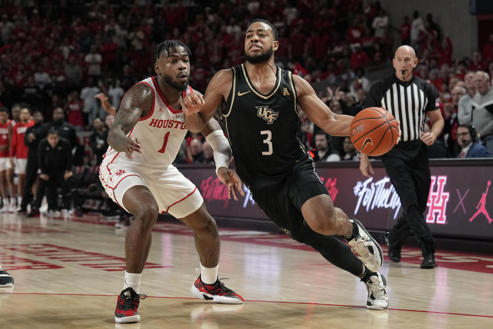 Central Florida's Darius Johnson (3) drives toward the basket as Houston's Jamal Shead (1) defends during the second half of an NCAA college basketball game Saturday, Dec. 31, 2022, in Houston. Houston won 71-65. (AP Photo/David J. Phillip)