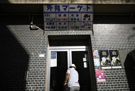 Resident Kohei Jinno, 79, closes the door of his shop at Kasumigaoka apartment complex which is located near the National Olympic Stadium in Tokyo September 18, 2013. REUTERS/Issei Kato