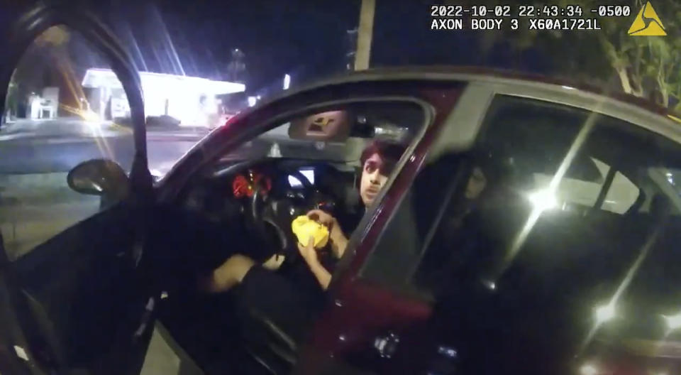 FILE - In this image taken from Oct. 2, 2022, police body camera video and released by the San Antonio Police Department, Erik Cantu looks toward San Antonio Police Officer James Brennand while holding a hamburger in a fast food restaurant parking lot as the officer opens the car door in San Antonio, Texas. Brennand, who shot the 17-year-old teen multiple times, has been indicted by a grand jury on two counts of aggravated assault by a public servant and one count of attempted murder, prosecutors said Thursday, Dec. 1, 2022. (San Antonio Police Department via AP, File)