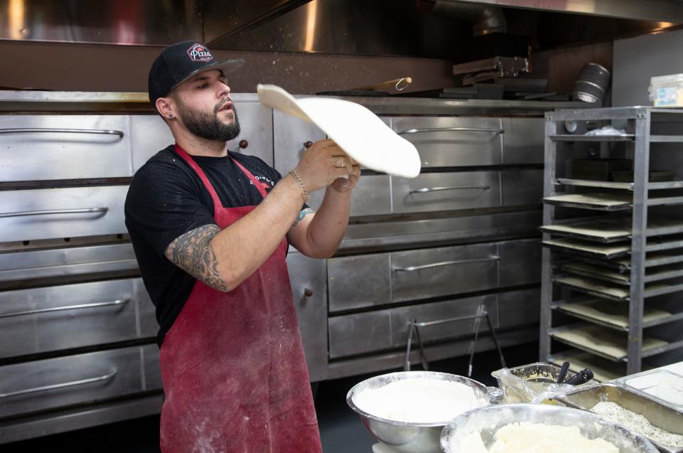 Owner Teddy Megaris preps dough for a large pie at Tramonto's Pizza in Ocean Township.