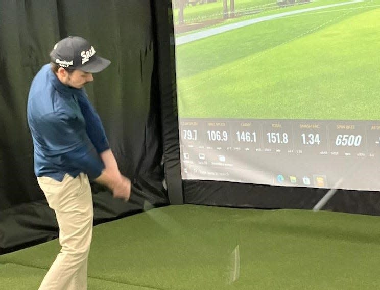 Jared Beachy hits golf balls at the TrackMan.