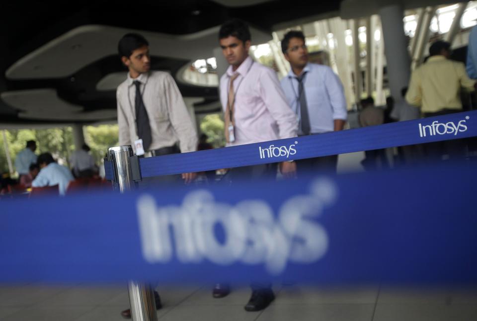 File photo shows employees of Indian software company Infosys walking past Infosys logos at their campus in the Electronic City area in Bangalore