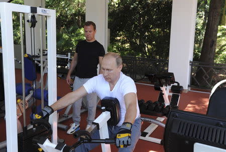 Russian President Vladimir Putin (R) and Prime Minister Dmitry Medvedev exercise in a gym at the Bocharov Ruchei state residence in Sochi, Russia, August 30, 2015. REUTERS/Michael Klimentyev/RIA Novosti/Kremlin