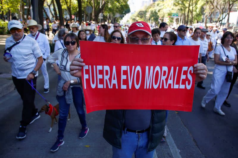 A demonstrator holds a sign during a march to protest against violence on the first anniversary of President Andres Manuel Lopez Obrador taking office, in Mexico City