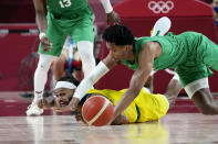 Australia's Patty Mills, left, and Nigeria's Chikezie Okpala, right, scramble for a loose ball during a men's basketball preliminary round game at the 2020 Summer Olympics, Sunday, July 25, 2021, in Saitama, Japan. (AP Photo/Eric Gay)