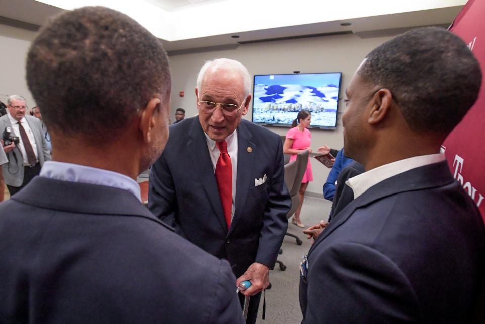 Valiant Cross Academy’s Fred Brock, left, and Anthony Brock, right, chat with Troy University Chancellor Jack Hawkins, center, as Troy transfers the deed to a building on their Montgomery campus to Valiant Cross Academy on Tuesday, June 27, 2023.