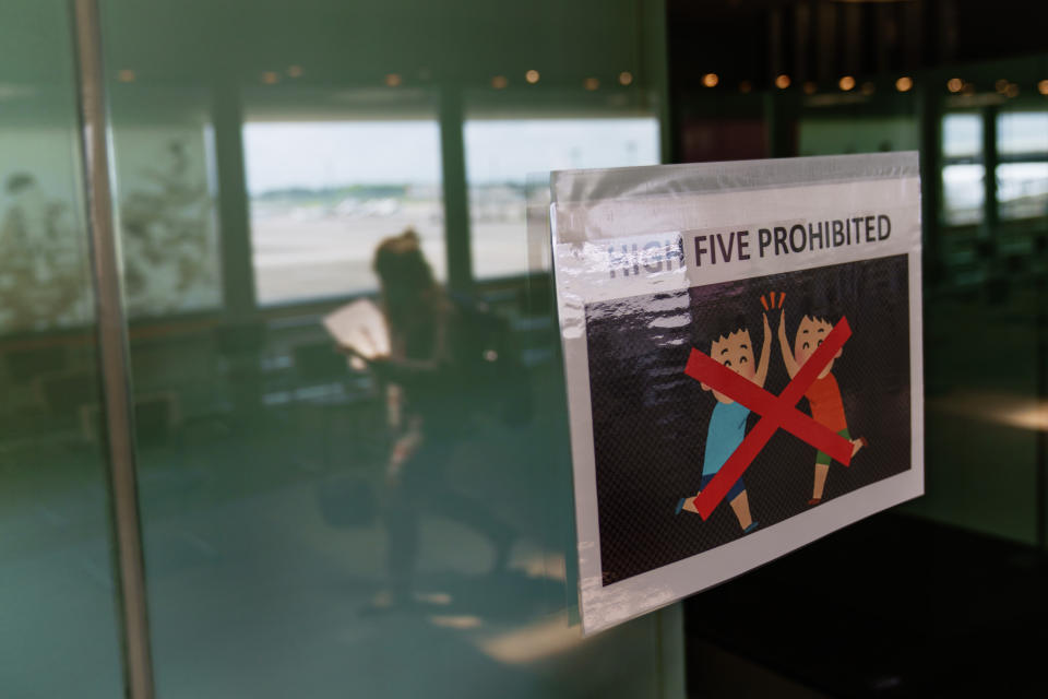 FILE - In this July 19, 2021, file photo, passenger walks past a sign for COVID-19 countermeasures after arriving at Narita International Airport in Narita, east of Tokyo. (AP Photo/David Goldman, File)