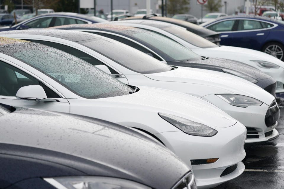 In this Sunday, May 9, 2021, photograph, a long row of unsold sedans and sports-utility vehicles sits at a Tesla dealership in Littleton, Colo. (AP Photo/David Zalubowski)