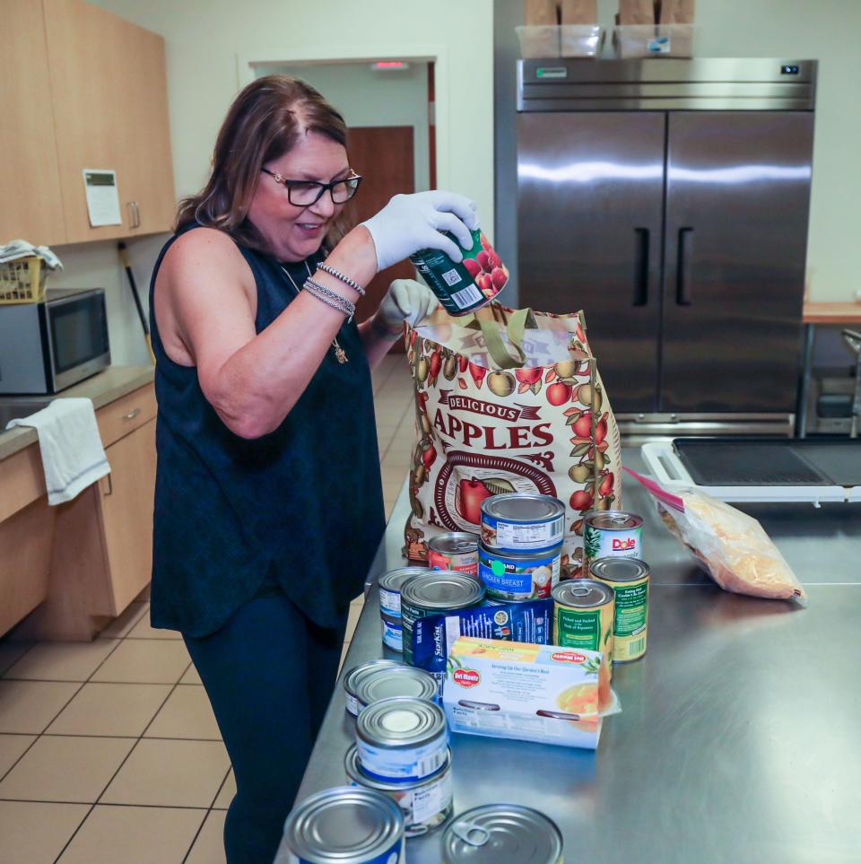 Volunteer Donna Banno sifts through food donated by a church pantry inside St. Ann's Place on June 17, 2022.