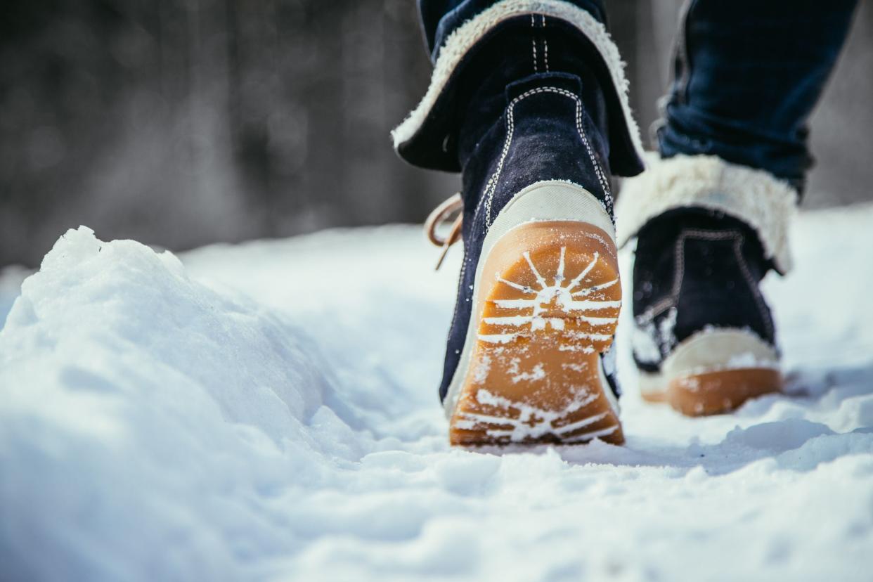 Girl in blue jeans is hiking in the wintertime, legs and shoes