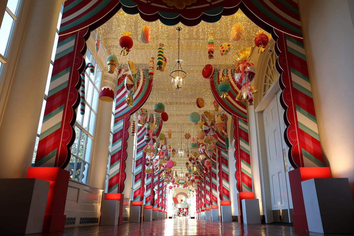Candy-themed ornaments hang from the ceiling of the hallway between the East Wing and the Residence at the White House. (Kevin Dietsch / Getty Images)