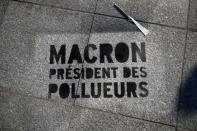 The slogan "Macron, President of polluters" is seen on the ground as environmental activists block the entrance of the Ministry of Ecology, Energy and Sustainable Development during a "civil disobedience action" to urge world leaders to act against climate change, in La Defense near Paris, France, April 19, 2019. REUTERS/Benoit Tessier