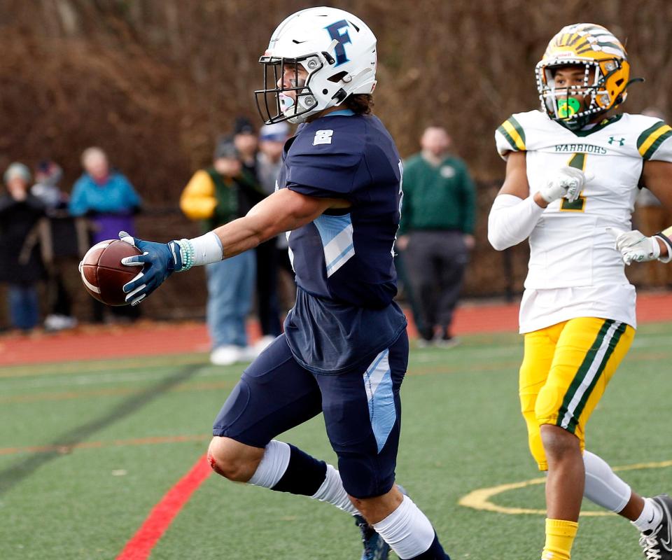 Franklin’s Shane Kindred (2) stretches the ball over the goal line in front of King Philip’s Jonathan Joseph (1) on a TD run during their Thanksgiving football match up at Franklin High. 