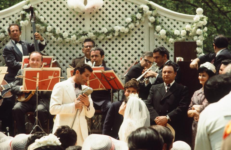 Johnny Fontane (Al Martino) sings to Connie (Talia Shire) in "The Godfather" wedding scene. A fully restored "The Godfather" trilogy is out March 22 on Blu-ray.