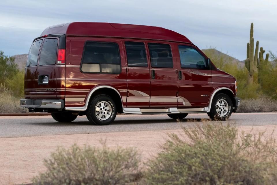 a red chevrolet express conversion van, shown from the rear