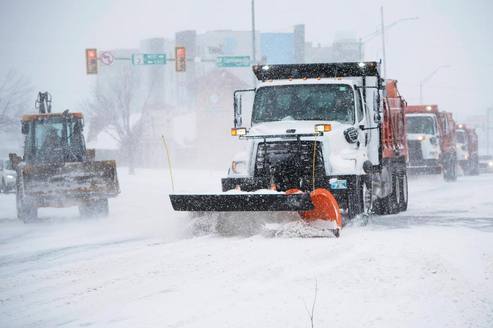 A snowplow works to clear an intersection in Oklahoma City Sunday.  Snow and ice blanketed large swaths of the U.S., prompting canceled flights, making driving perilous and reaching into areas as far south as Texas’ Gulf Coast.