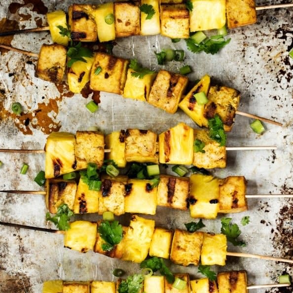 Charred skewers of tofu, scallions, cilantro, and pineapple