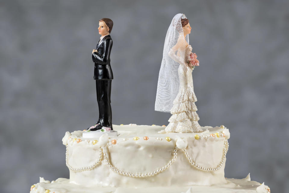 Wedding cake with bride and groom facing away from each other.