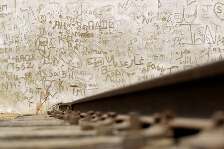 Graffiti covers a wall built to block pedestrian access along the track of the disused Karachi Circular Railway line in Karachi, Pakistan May 23, 2017. REUTERS/Caren Firouz