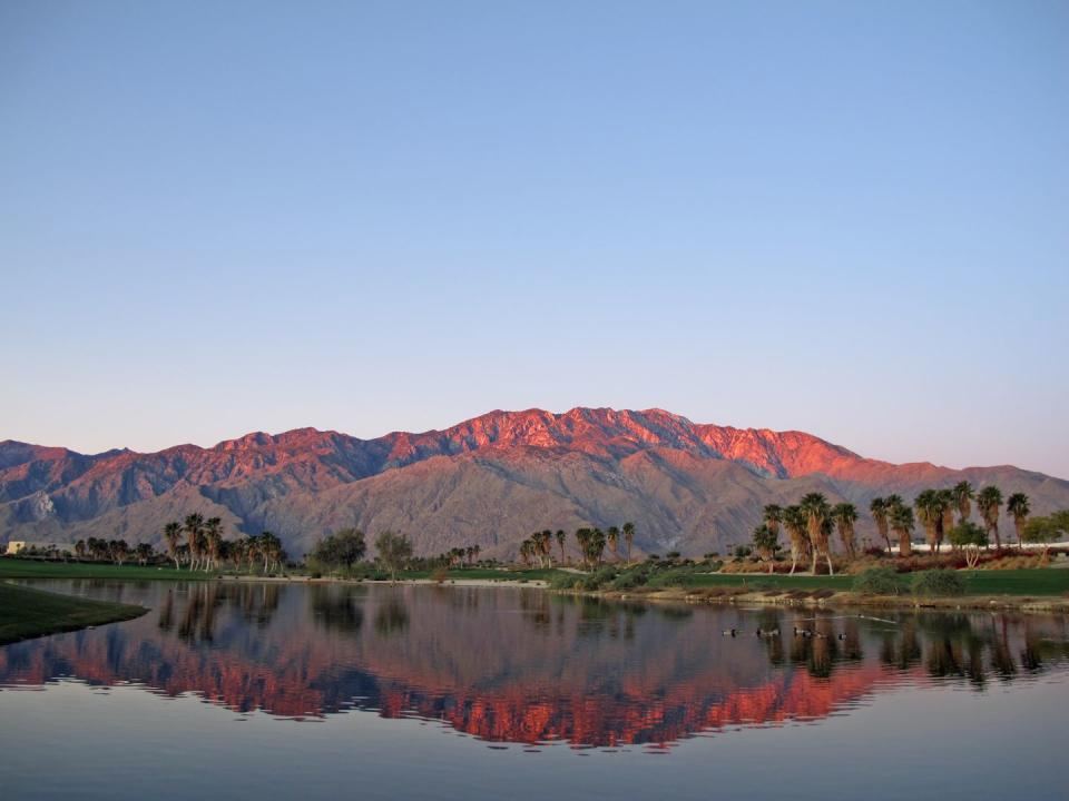 best honeymoon destinations in us palm springs golf course at dawn with sunrise kissed mountains